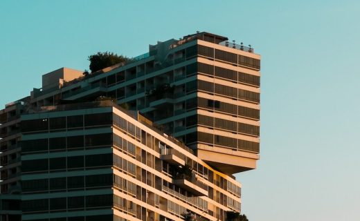 a plane flying over a tall building in the sky